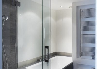 Badkamer met bad douche en toilet en dubbele wastafel